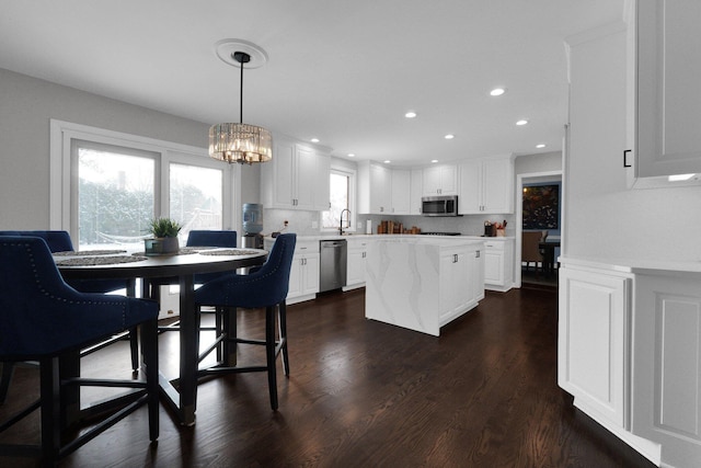 dining room with a notable chandelier, dark hardwood / wood-style flooring, and sink