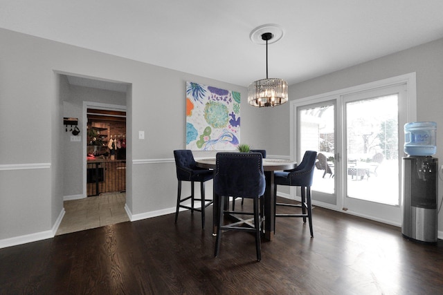 dining space with dark hardwood / wood-style flooring and a notable chandelier