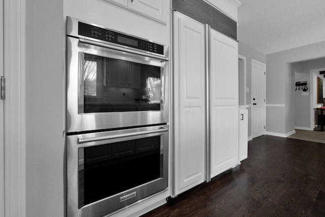 kitchen featuring white cabinetry, double oven, and dark wood-type flooring