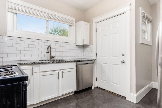 kitchen with dishwasher, white cabinets, sink, decorative backsplash, and dark stone countertops