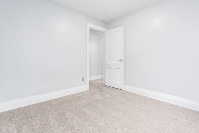 carpeted empty room featuring a textured ceiling