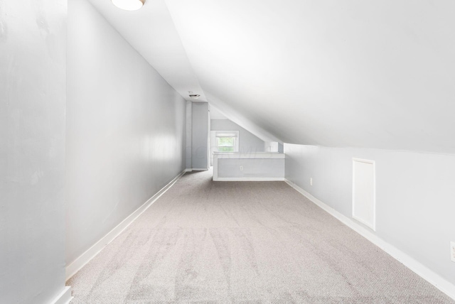 bonus room featuring light colored carpet and lofted ceiling