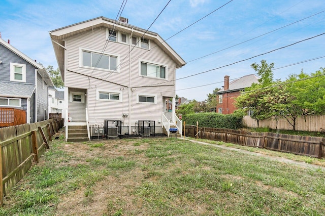 rear view of house featuring a lawn