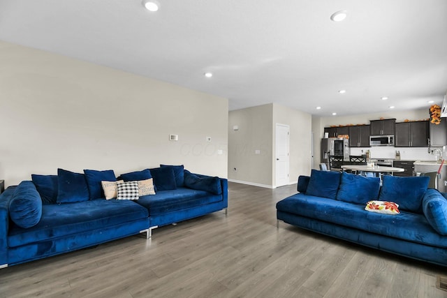 living room with sink and light wood-type flooring