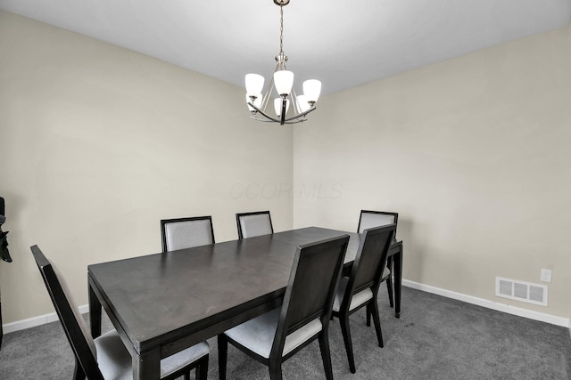 dining room featuring dark carpet and an inviting chandelier