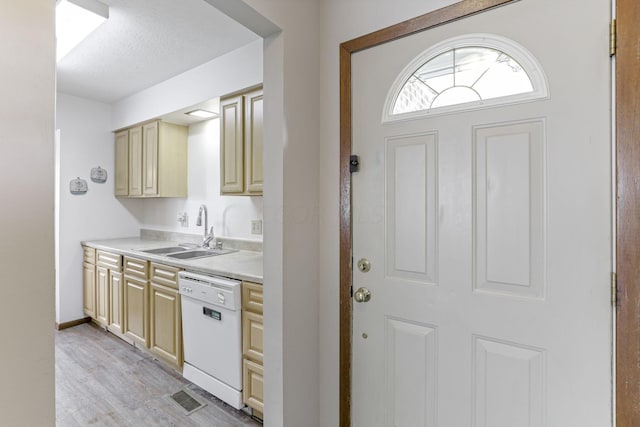 kitchen with sink, white dishwasher, light hardwood / wood-style floors, and a textured ceiling