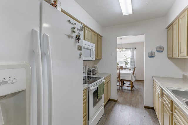 kitchen featuring sink, a chandelier, decorative light fixtures, white appliances, and light hardwood / wood-style floors