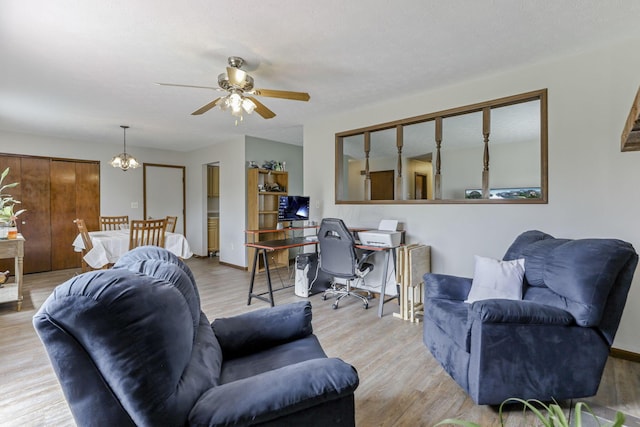 living room featuring light hardwood / wood-style floors and ceiling fan with notable chandelier