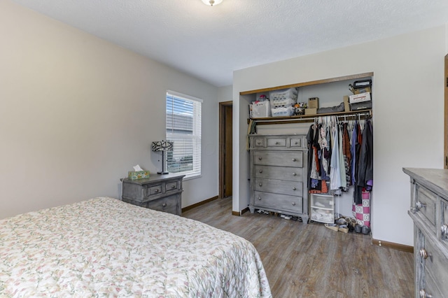 bedroom with a textured ceiling, light hardwood / wood-style flooring, and a closet