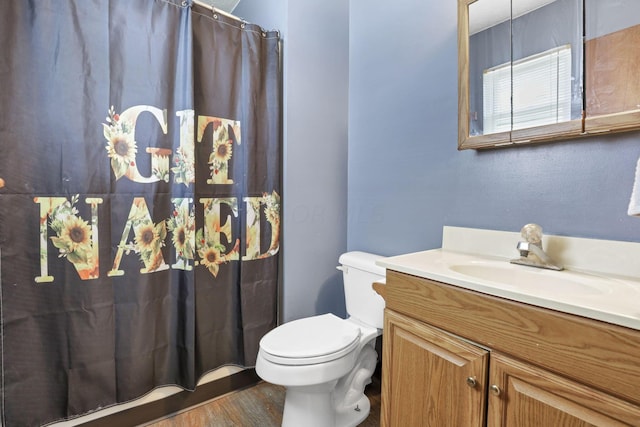 bathroom featuring wood-type flooring, vanity, and toilet