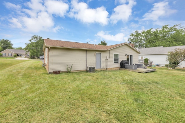 rear view of property featuring a yard and cooling unit