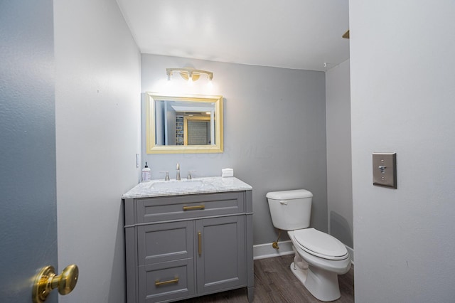 bathroom featuring vanity, wood-type flooring, and toilet