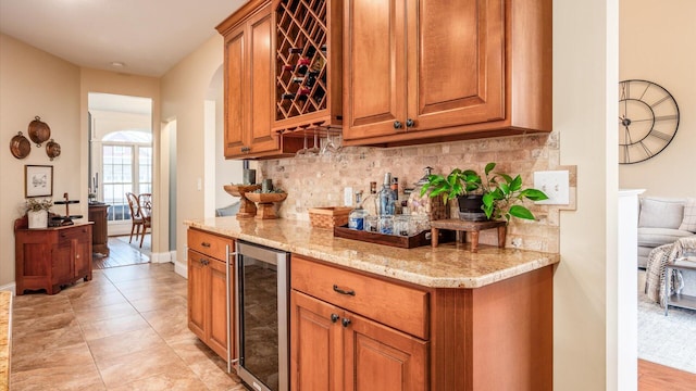 bar featuring decorative backsplash, light tile patterned floors, light stone countertops, and wine cooler