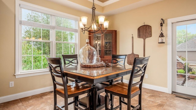 tiled dining area featuring plenty of natural light, ornamental molding, and a chandelier