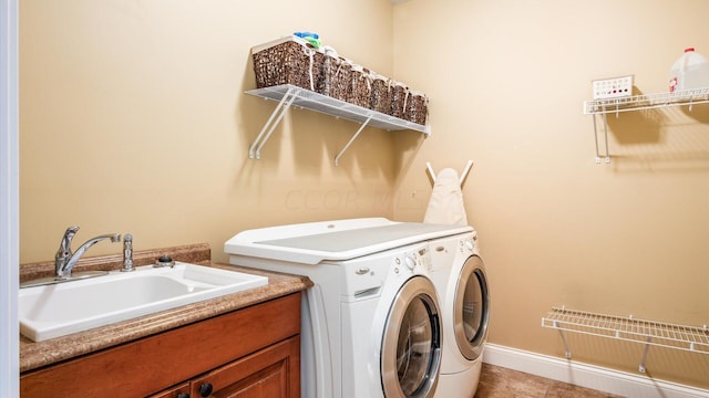 laundry room with tile patterned floors, separate washer and dryer, and sink