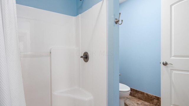 bathroom with toilet and a shower with shower curtain