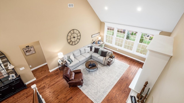 living room with a high ceiling and dark wood-type flooring