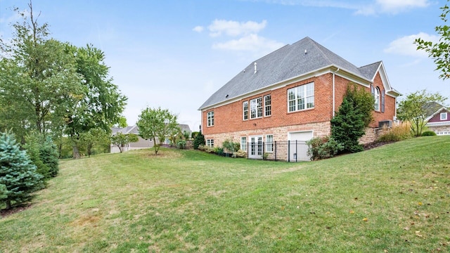 rear view of house featuring a garage and a yard