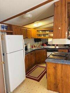 kitchen with tasteful backsplash and white fridge