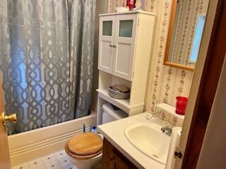 full bathroom with shower / bath combination with curtain, vanity, and toilet