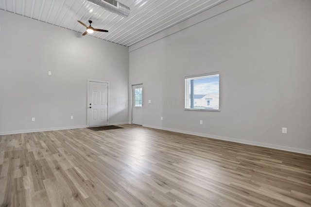 empty room featuring light wood-type flooring, high vaulted ceiling, ceiling fan, and wooden ceiling