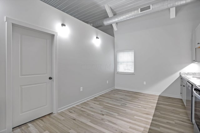 interior space featuring beam ceiling and light wood-type flooring