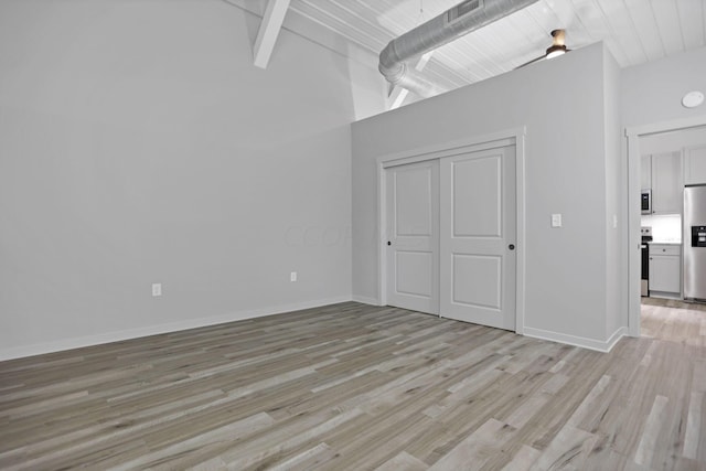 interior space with beam ceiling, high vaulted ceiling, and light hardwood / wood-style flooring