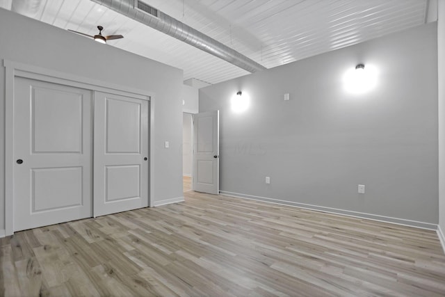 unfurnished bedroom featuring ceiling fan, a closet, and light wood-type flooring