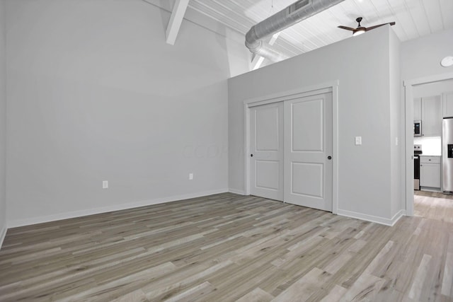 interior space with vaulted ceiling with beams, ceiling fan, and light hardwood / wood-style floors