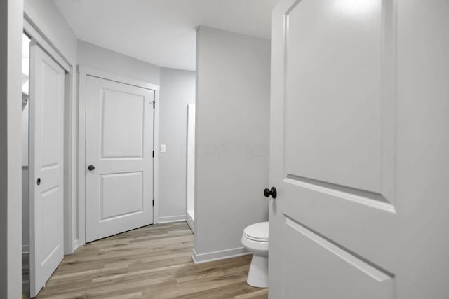 bathroom with hardwood / wood-style flooring and toilet