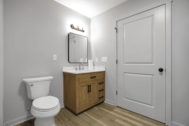 bathroom with vanity, wood-type flooring, and toilet