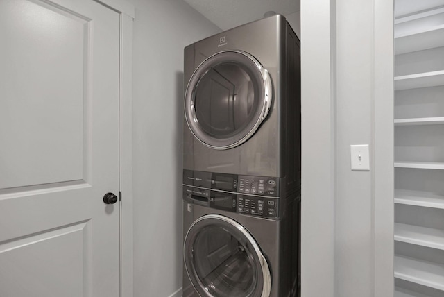 clothes washing area featuring stacked washer / drying machine