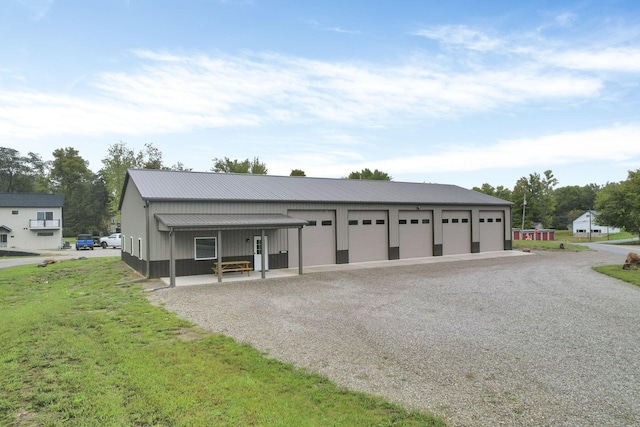 garage featuring covered porch and a yard