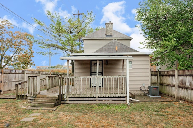 rear view of house with central AC unit, a yard, and a wooden deck