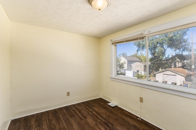 spare room with wood-type flooring and a textured ceiling