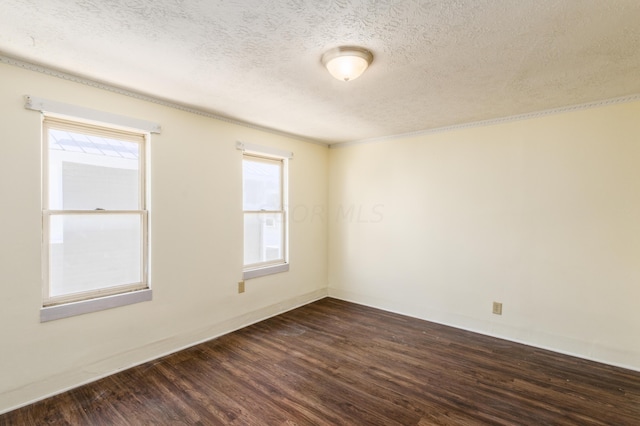 empty room with a textured ceiling and dark hardwood / wood-style flooring