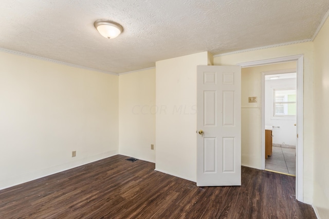 spare room featuring dark hardwood / wood-style flooring and a textured ceiling