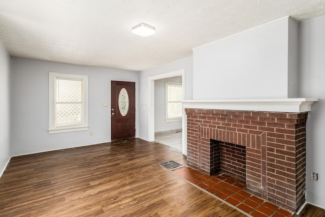 interior space featuring a fireplace, dark hardwood / wood-style flooring, and a textured ceiling