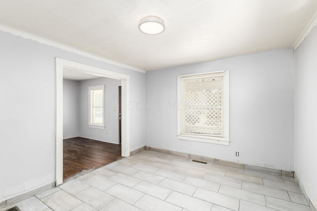 empty room with crown molding and light hardwood / wood-style floors