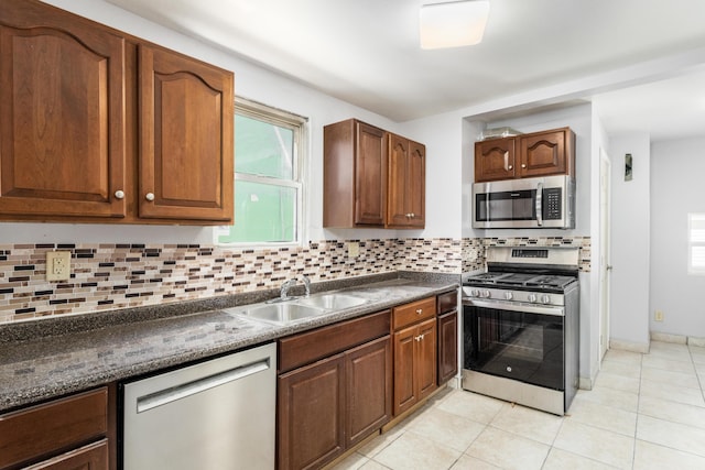 kitchen with tasteful backsplash, a healthy amount of sunlight, sink, and stainless steel appliances