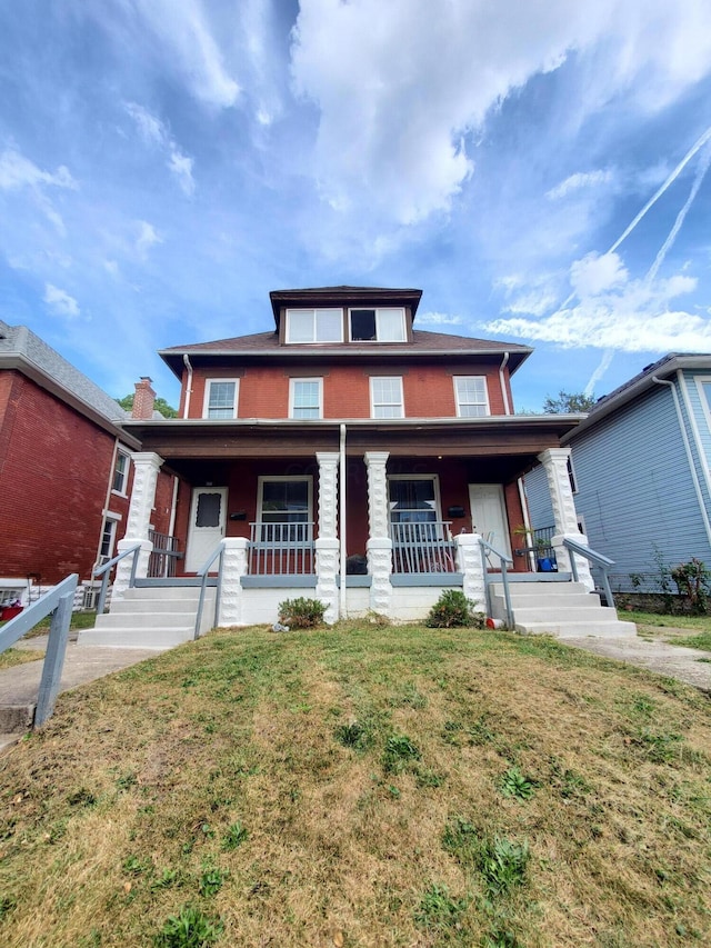 view of front of house featuring covered porch and a front lawn