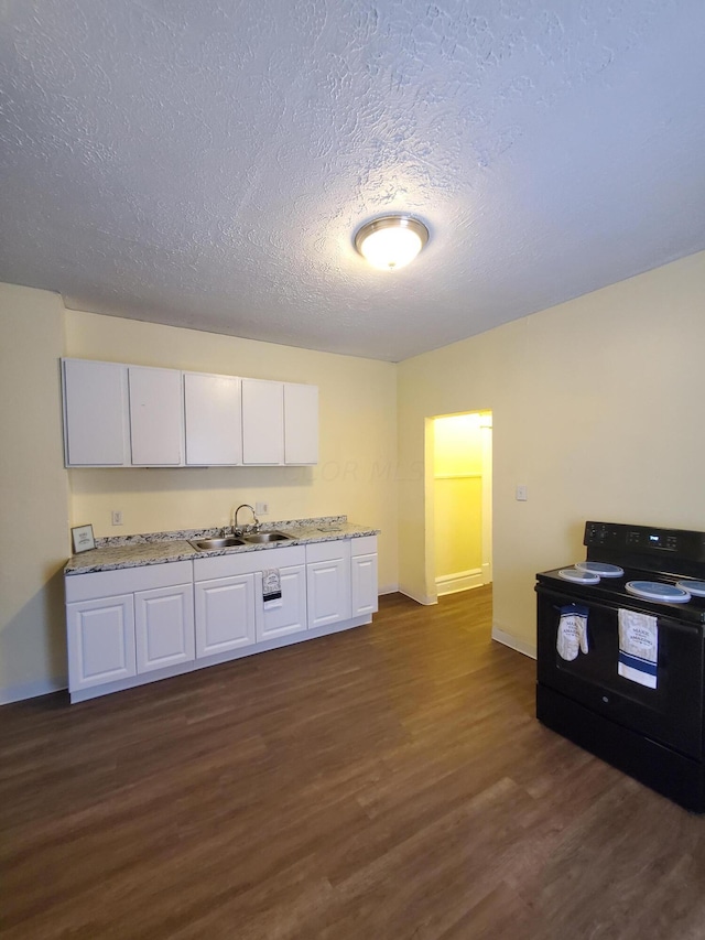 kitchen featuring white cabinets, black electric range oven, dark hardwood / wood-style flooring, and sink