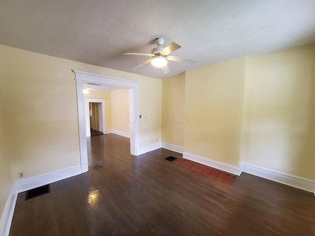 unfurnished room with a textured ceiling, ceiling fan, and dark wood-type flooring