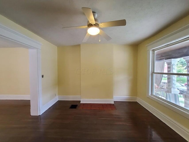 spare room with ceiling fan and dark wood-type flooring