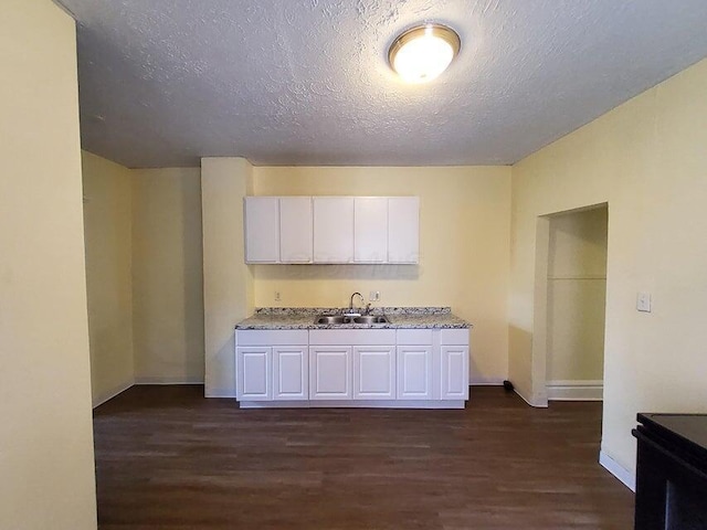 kitchen featuring white cabinetry, dark hardwood / wood-style flooring, a textured ceiling, and sink