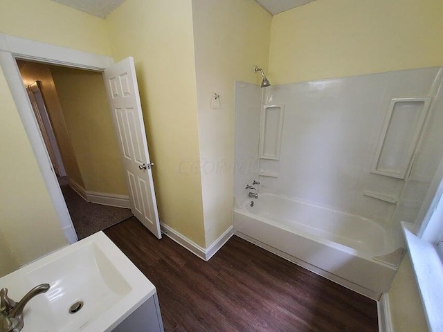 bathroom with hardwood / wood-style floors, shower / bathtub combination, and sink