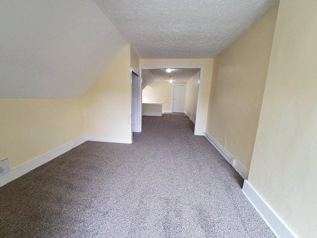 bonus room featuring a textured ceiling, lofted ceiling, and carpet floors