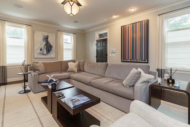 living room featuring plenty of natural light, light wood-type flooring, and ornamental molding