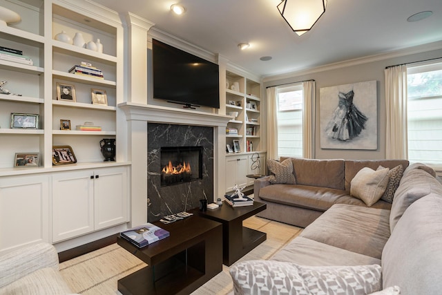 living room featuring a fireplace, built in features, and ornamental molding