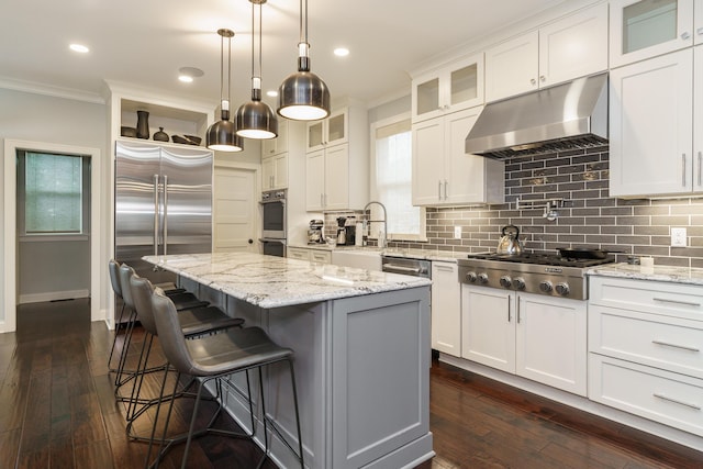 kitchen featuring white cabinets, a center island, dark hardwood / wood-style flooring, and stainless steel appliances